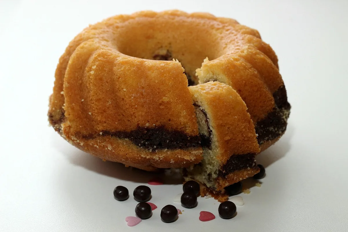 Golden Bundt cake cut open to show a dark swirl through the middle, similar to a sock it to me cake
