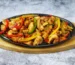 Chopped seared chicken with bell peppers and onion in a cast iron skillet, similar to this chipotle chicken recipe