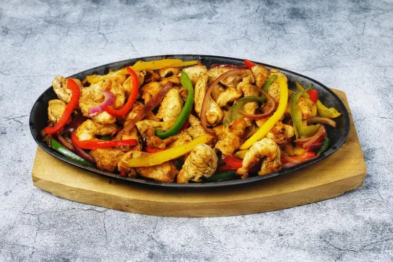 Chopped seared chicken with bell peppers and onion in a cast iron skillet, similar to this chipotle chicken recipe