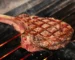 Thick tomahawk steak with crosshatch grill marks on hot grates, similar to the ribeye in this how to grill steak guide