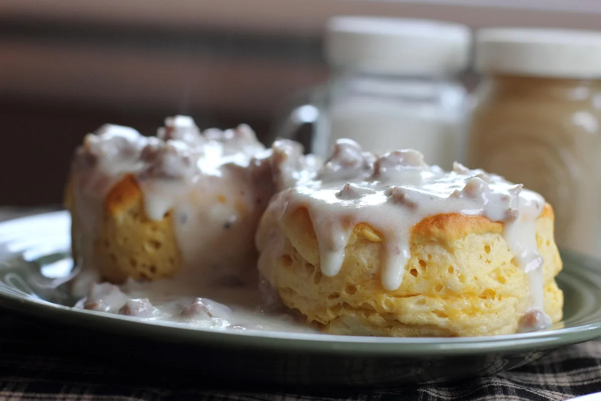 Split biscuits covered in thick creamy white gravy with meat, similar to creamed chipped beef served over biscuits