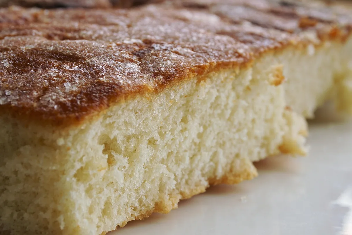 Close-up of a soft golden sheet cake square with a caramelized cinnamon sugar top