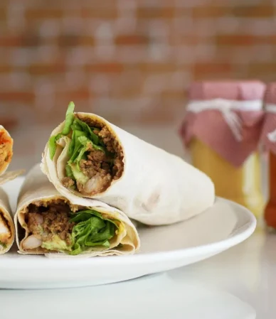 Flour tortilla wraps cut in half showing chicken and lettuce filling, similar to a buffalo chicken wrap