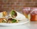 Flour tortilla wraps cut in half showing chicken and lettuce filling, similar to a buffalo chicken wrap
