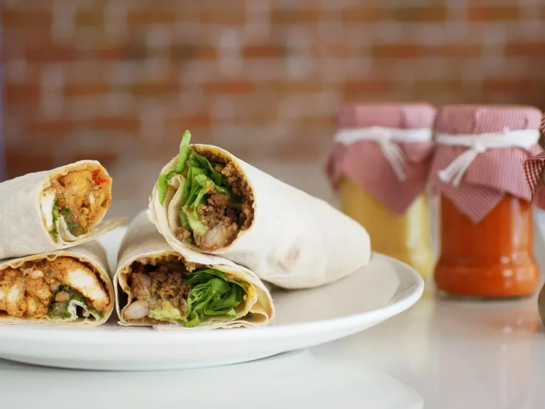 Flour tortilla wraps cut in half showing chicken and lettuce filling, similar to a buffalo chicken wrap