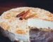 Sliced cheesecake with a golden cinnamon swirl top and cinnamon sticks, similar to churro cheesecake