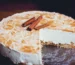 Sliced cheesecake with a golden cinnamon swirl top and cinnamon sticks, similar to churro cheesecake