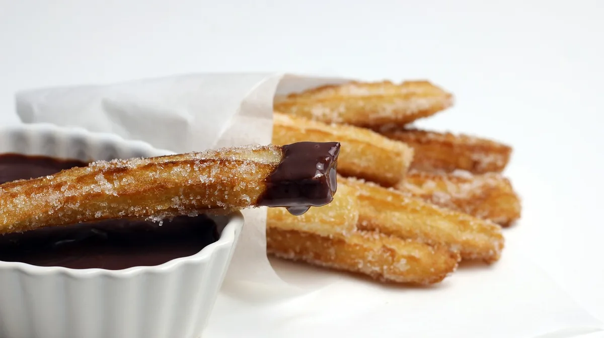 Cinnamon-sugar churros with chocolate dipping sauce, the flavor that inspires churro cheesecake bars