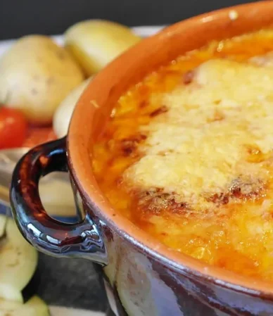 Cheesy potato casserole browned on top in a baking dish, one of the ground beef casserole recipes on this page