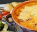 Cheesy potato casserole browned on top in a baking dish, one of the ground beef casserole recipes on this page