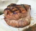 Thick grilled tenderloin steak with a dark peppered crust, similar to the pan-seared filet mignon in this recipe