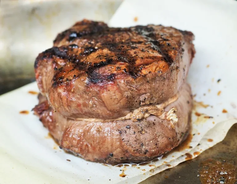 Thick grilled tenderloin steak with a dark peppered crust, similar to the pan-seared filet mignon in this recipe