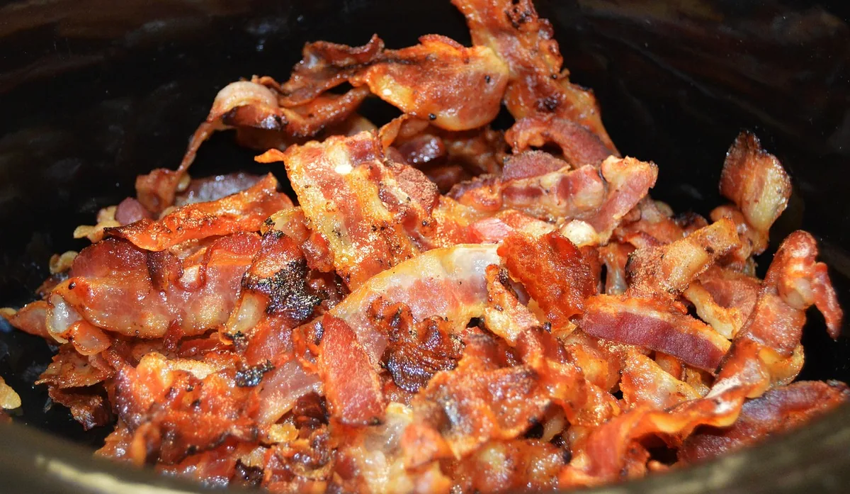 Crisp chopped bacon in a skillet, cooked for the chicken bacon Caesar filling
