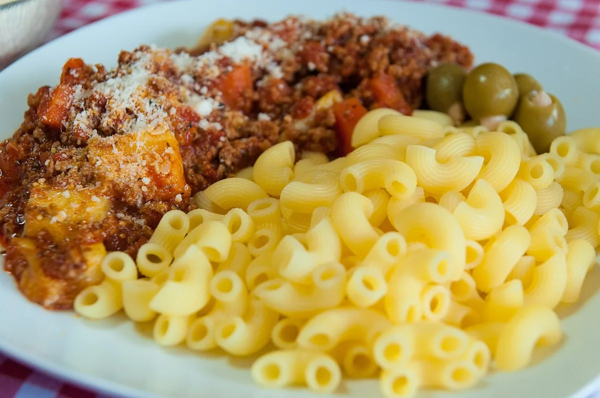 Elbow macaroni served with a cheesy ground beef and tomato sauce on a plate