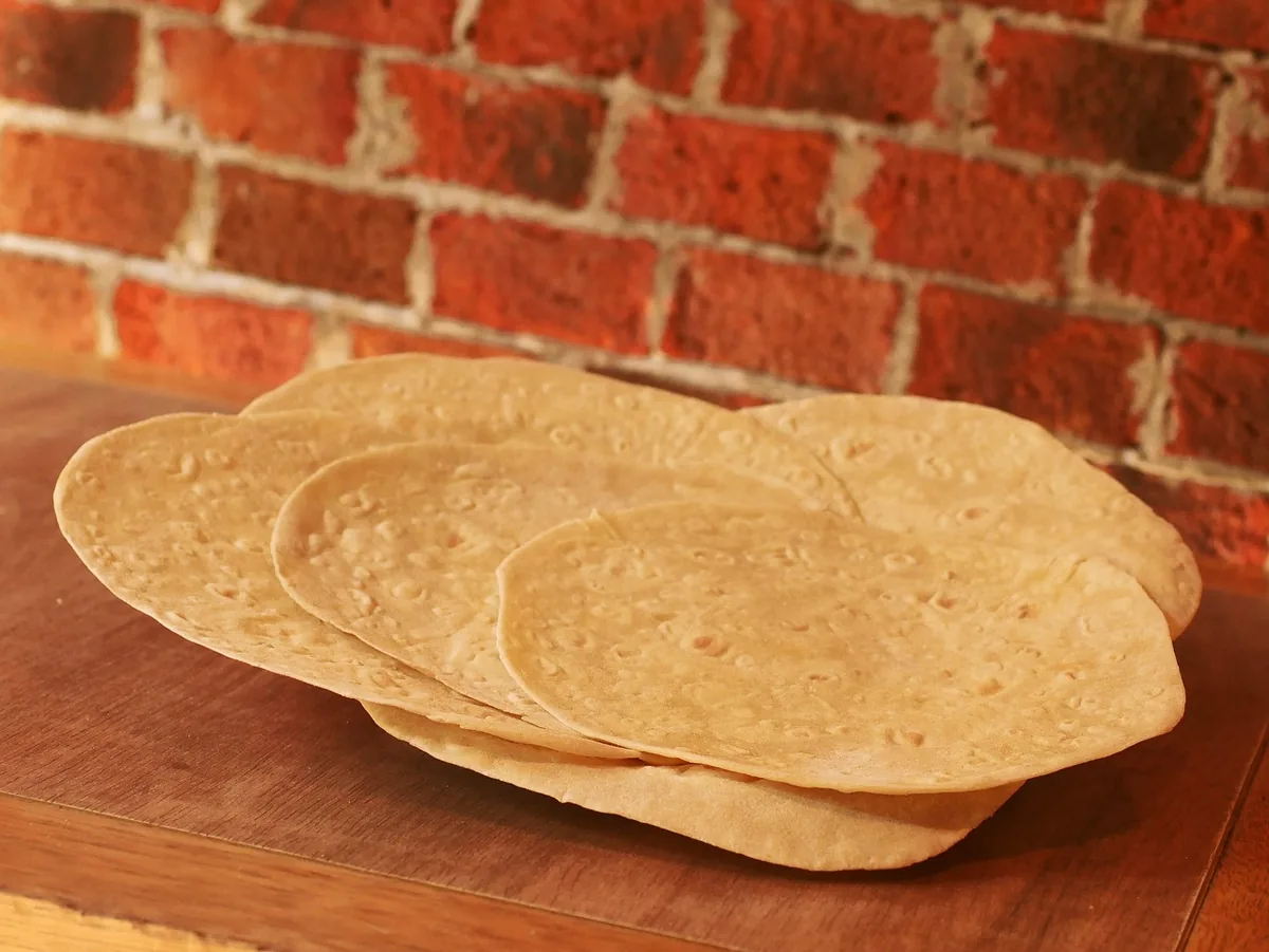 A stack of soft tortillas ready to warm and roll for beef enchiladas
