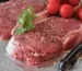 Raw beef steaks seasoned with pepper and herbs on foil, ready for a steak marinade