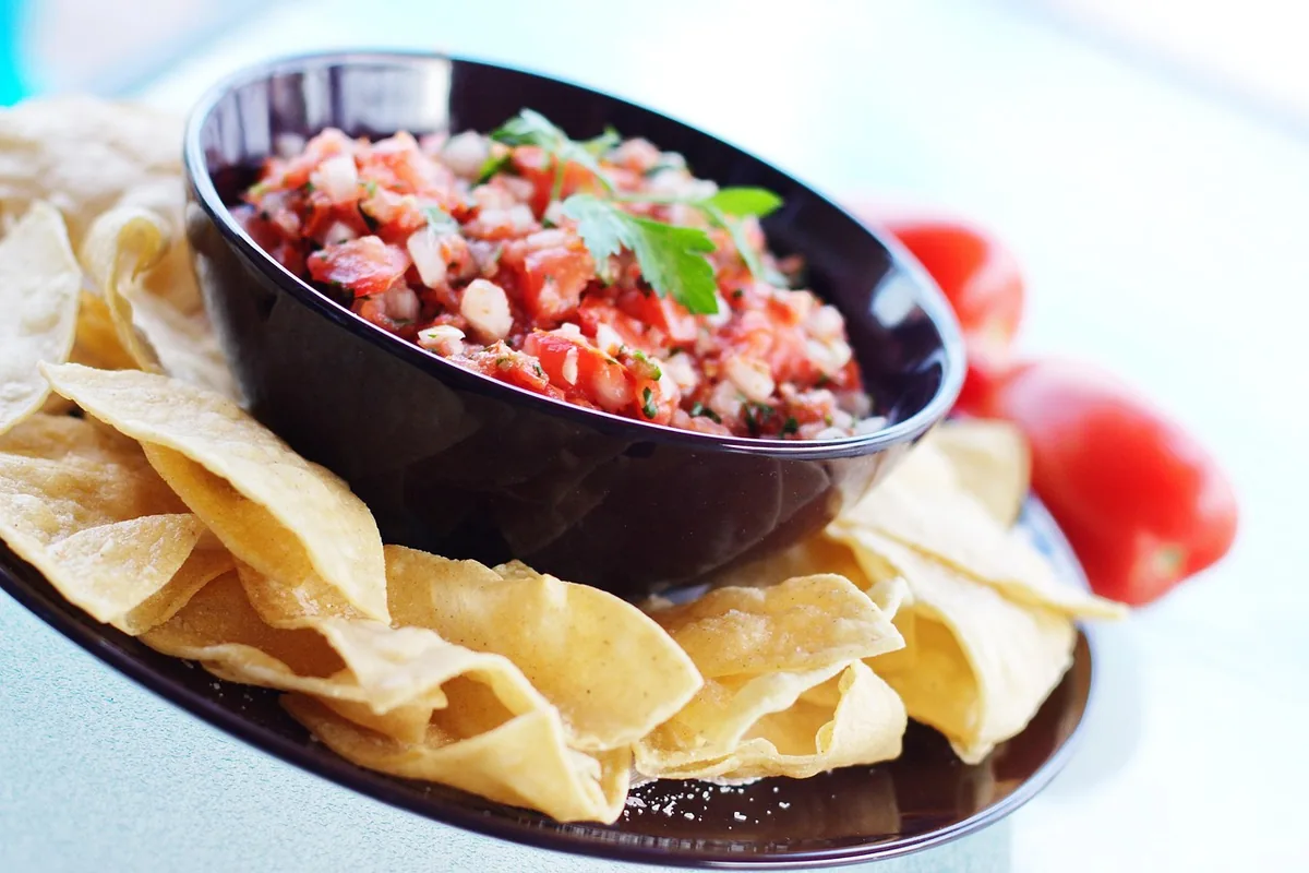 Bowl of chunky tomato salsa with tortilla chips, the salsa used to cook slow cooker chicken tacos