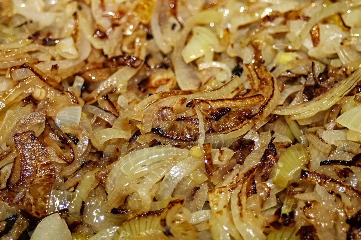 Golden caramelized onions cooking in a pan for liver and onions