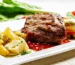 Grilled steak with golden roasted potatoes on a white plate, a steak and potatoes dinner