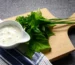 Creamy herb sauce in a white bowl with fresh herbs on a wooden board, similar to this crab cake sauce