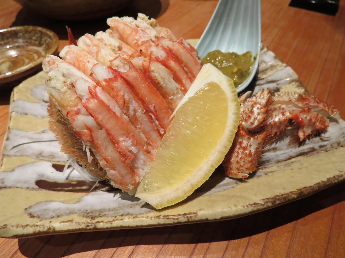 Cooked crab legs and crab meat with a lemon wedge, the seafood this crab cake sauce goes with