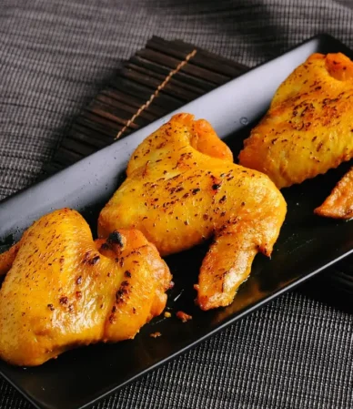 Spice-rubbed baked chicken wings on a black tray, similar to these dry rub chicken wings