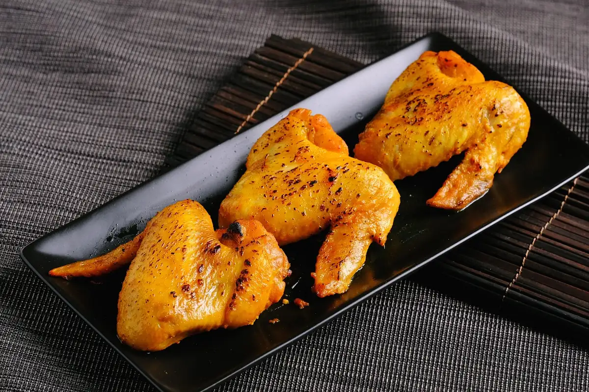 Spice-rubbed baked chicken wings on a black tray, similar to these dry rub chicken wings