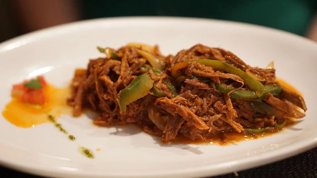 Plate of saucy shredded beef with strips of green pepper, a Latin-style pulled beef dish
