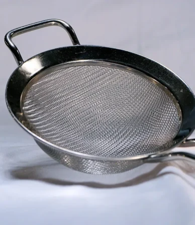 Fine-mesh metal sieve for sifting flour and cornstarch, the key tool in how to make cake flour at home