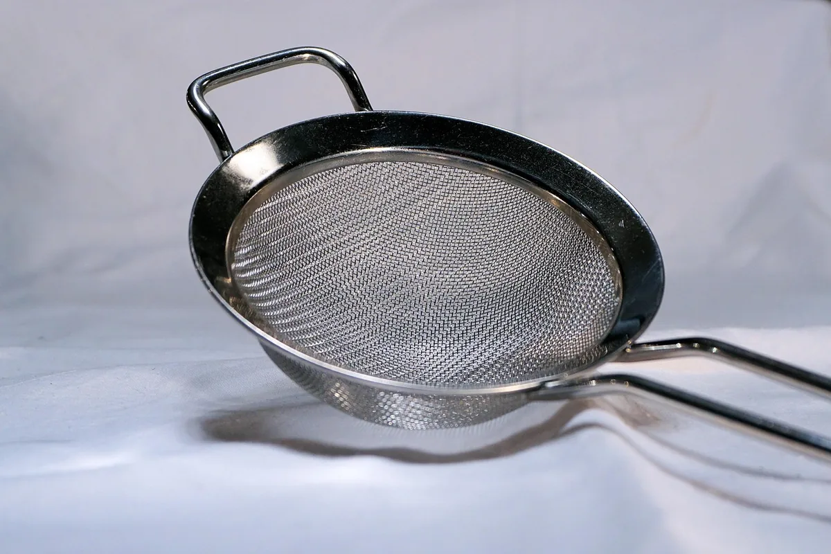 Fine-mesh metal sieve for sifting flour and cornstarch, the key tool in how to make cake flour at home
