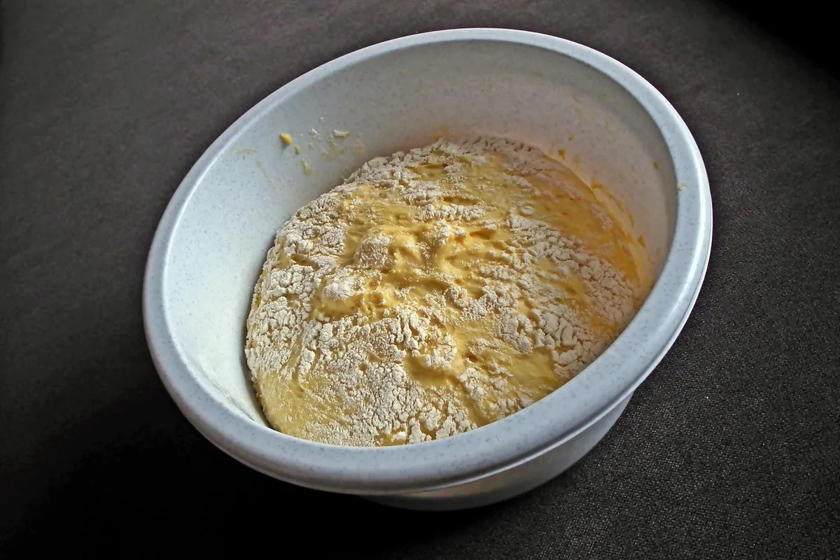 Bowl of flour with eggs and butter ready to mix into a cake batter