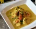 Pieces of chicken in a creamy golden sauce with herbs in a white dish, like chicken stroganoff