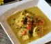 Pieces of chicken in a creamy golden sauce with herbs in a white dish, like chicken stroganoff