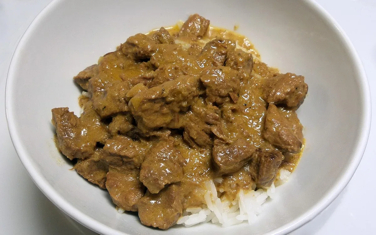 Bowl of creamy stroganoff with tender meat in sauce served over rice