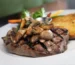 Grilled sirloin steak topped with sautéed mushrooms on a plate, like a petite sirloin steak dinner