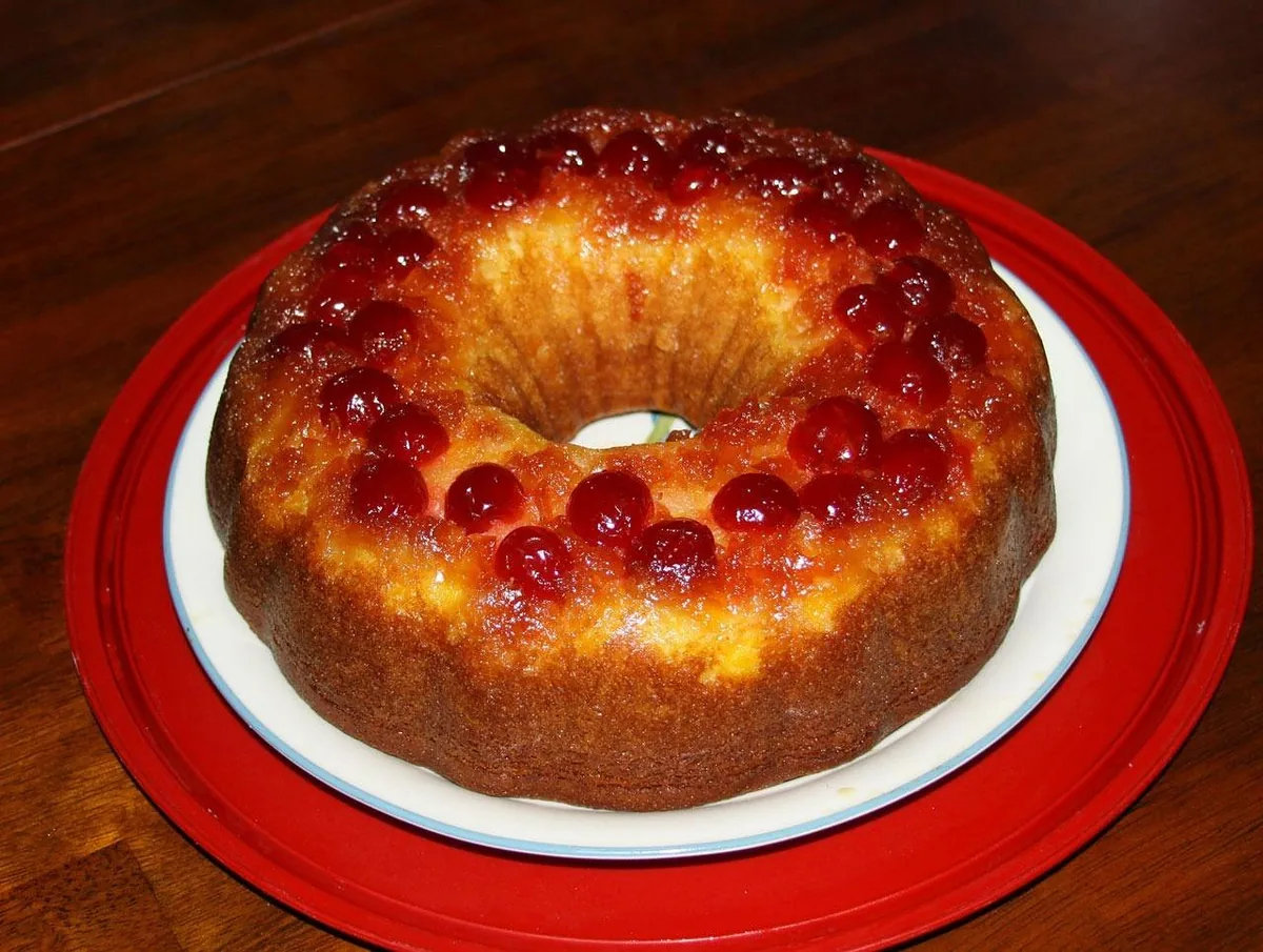 Pineapple upside-down cake baked in a Bundt pan, topped with caramelized pineapple and cherries
