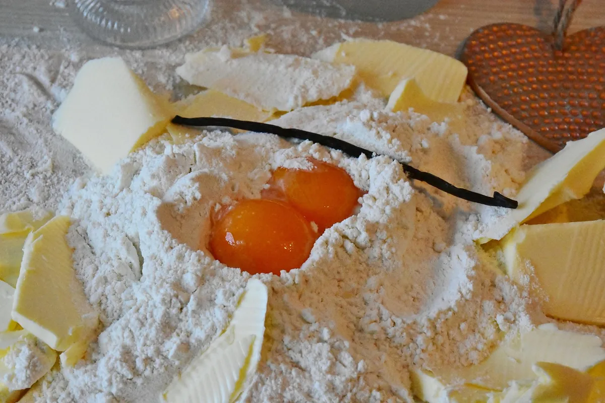Flour with egg yolks, cubes of butter and a vanilla bean, the base ingredients for vanilla cake