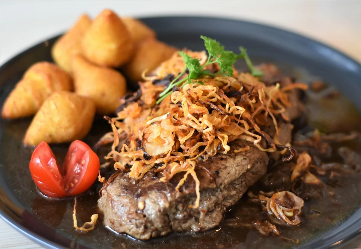 Smothered steak in dark onion gravy topped with crispy onions, the result of this beef top round steak recipe