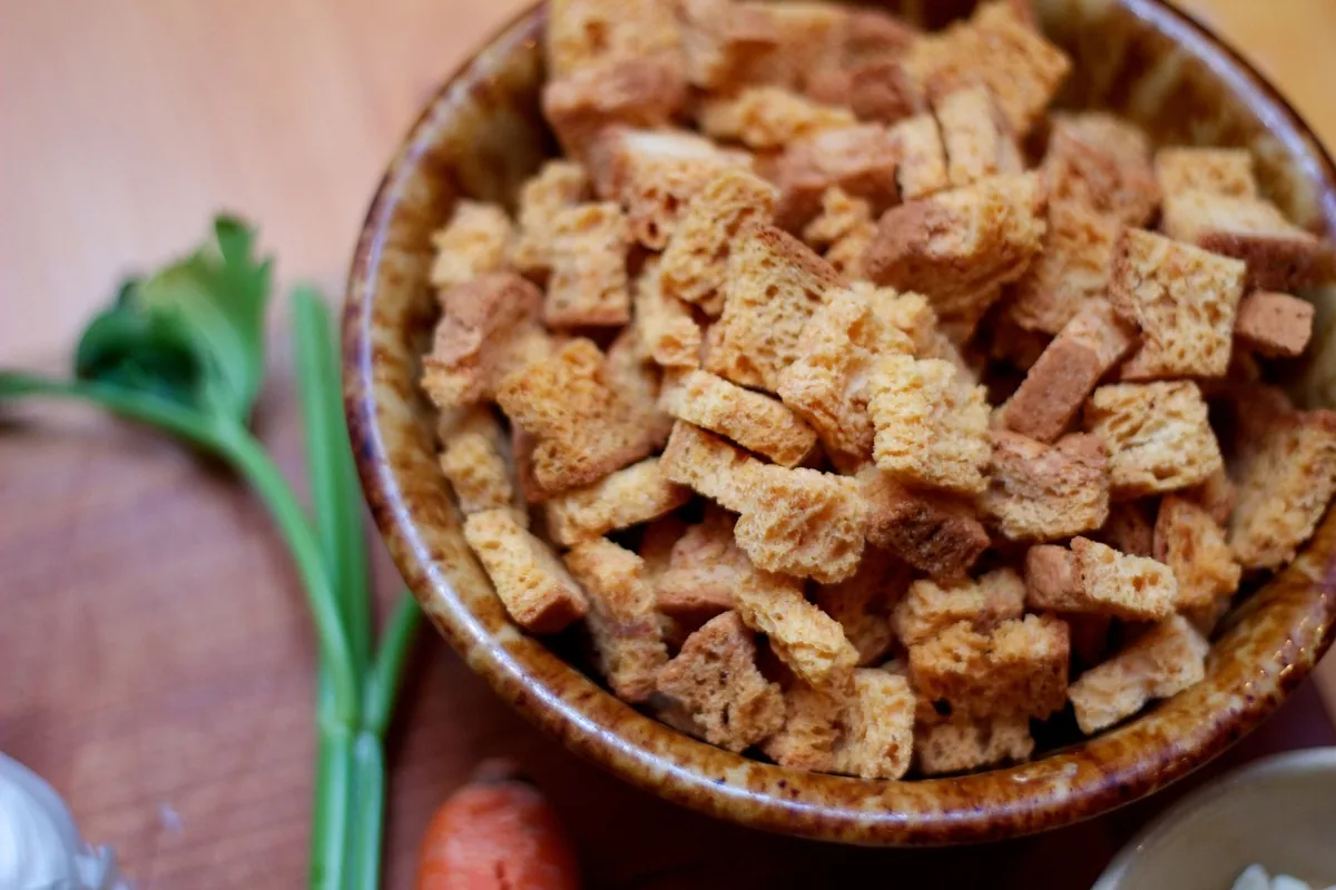 Bowl of dried seasoned bread cubes for stuffing next to celery