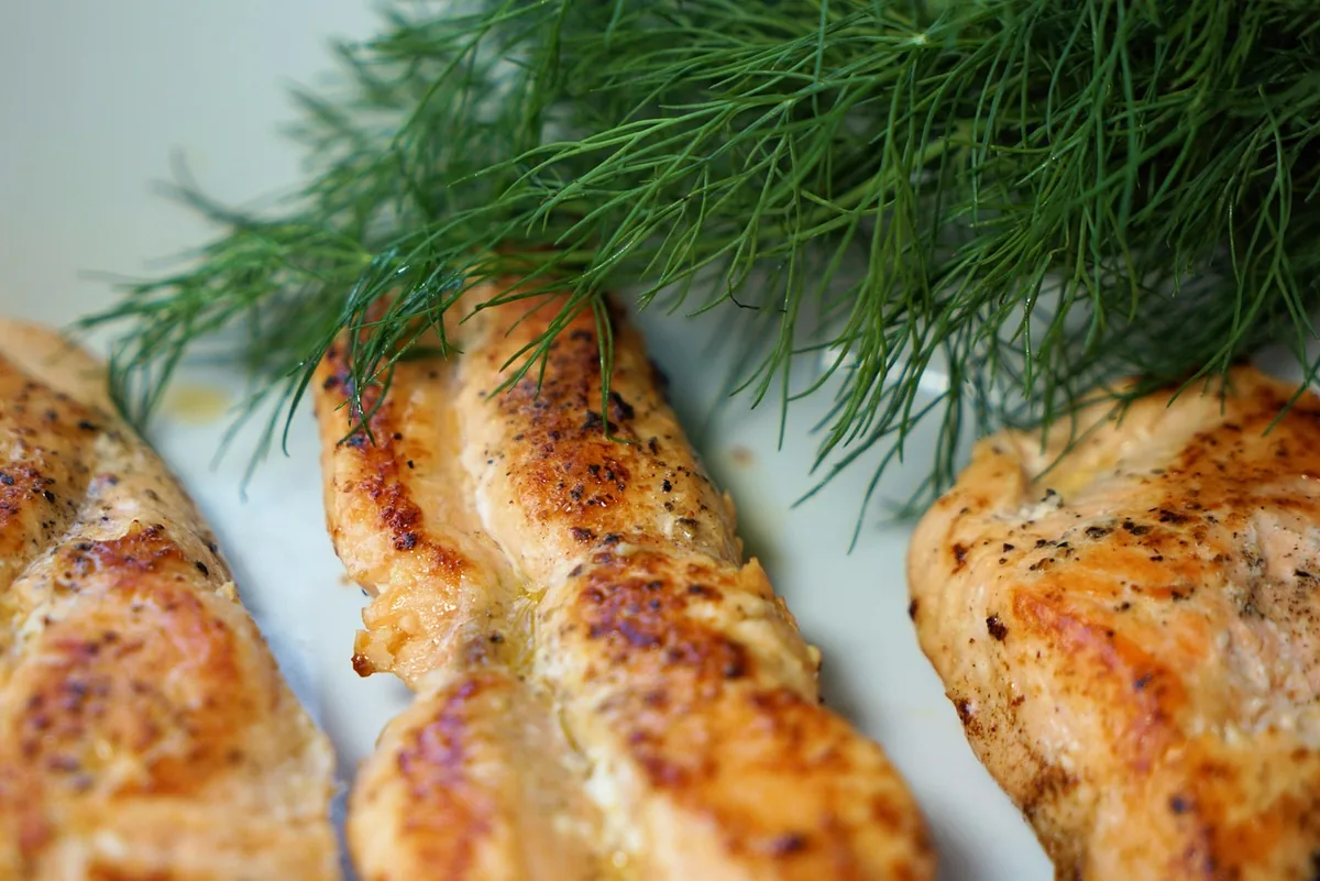 Golden cooked salmon fillets with fresh dill