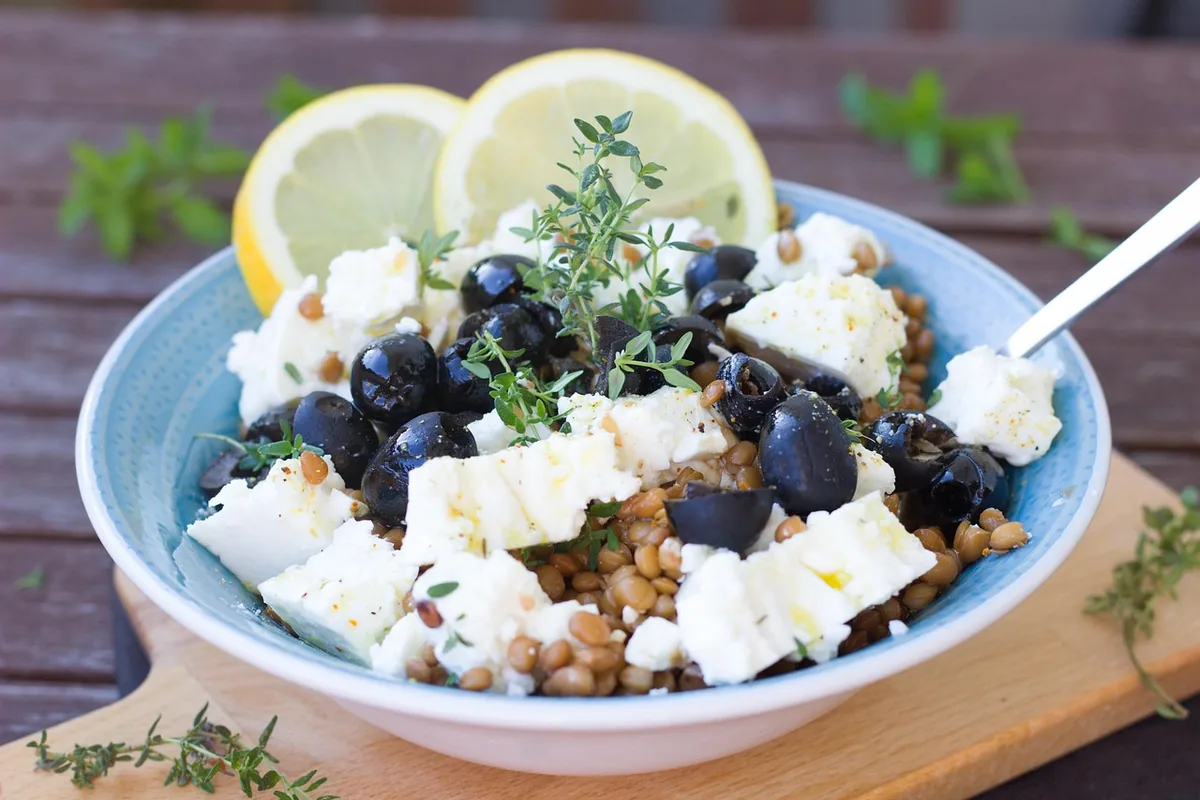 Lentil salad with feta, black olives, lemon and thyme in a blue bowl, one of these easy lentil recipes