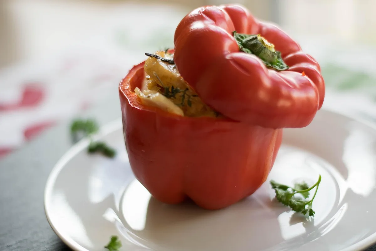 Red bell pepper stuffed with a savory filling on a white plate