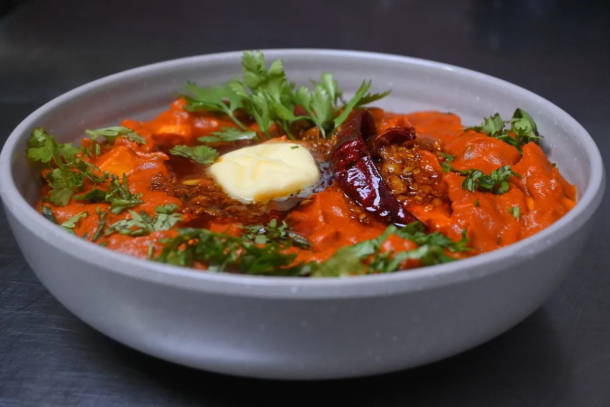Paneer in a rich tomato butter gravy topped with butter, dried chiles and cilantro, one of these easy paneer recipes